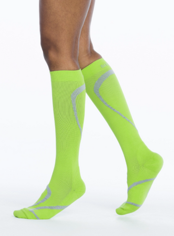 person wearing neon green knee high compression socks